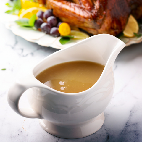 A rich and savory beef bone broth gravy in a gravy boat, with a smooth, thickened texture, ready to be served over meats and potatoes.