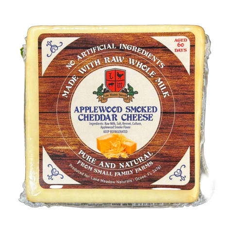 Close-up of Applewood Smoked Cheddar Cheese from Lake Meadow Naturals, showcasing its rich, smoky flavor and distinctive texture. The image highlights the cheese’s artisanal quality and the Applewood smoking process, which imparts a robust, savory taste. Made with raw whole milk, this cheese offers a delicious and gourmet addition to any cheese platter.