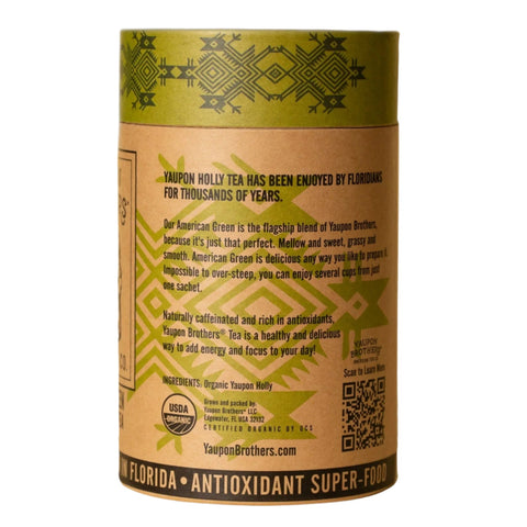Back view of the cylindrical package for American Green Yaupon Holly Tea, showcasing detailed product information. The label describes the tea as certified organic, naturally caffeinated, and tannin-free, with 16 natural fiber sachets inside. It highlights the tea's light, crisp flavor, its historic significance, and eco-friendly packaging made in the USA.