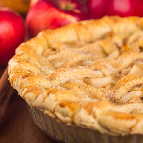 A freshly baked apple pie with a golden, flaky crust and a lattice top, filled with cinnamon-spiced apple slices.