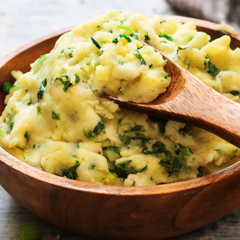 A bowl of creamy mashed potatoes topped with a pat of butter, ready to serve as the perfect side dish.