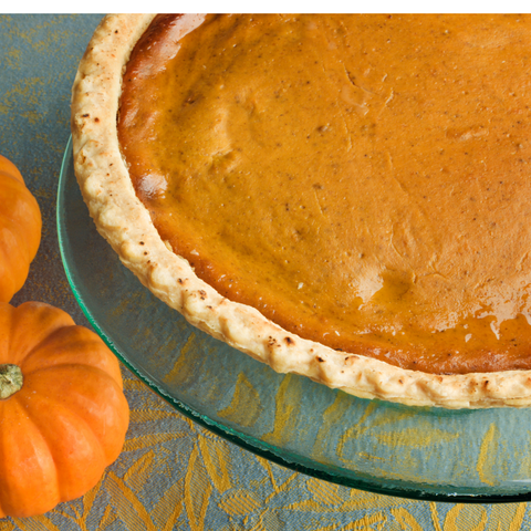 A freshly baked pumpkin pie with a golden, flaky crust, topped with a sprinkle of cinnamon and ready to be served for the holiday season.