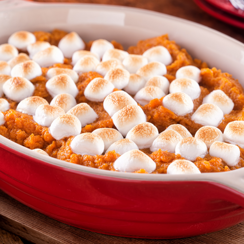 A serving of Thanksgiving sweet potatoes topped with a golden, puffed marshmallow crust and a buttery, flour topping.