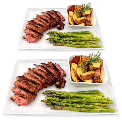 Steak Dinner for Two – A perfectly cooked New York Strip Steak, served with tender asparagus and golden roasted baby potatoes. A gourmet meal, beautifully plated for a romantic dinner at home. Order now for the perfect date night experience!